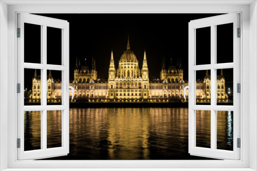 The Hungarian parliament is reflected in the water in budapest on the banks of the Danube.