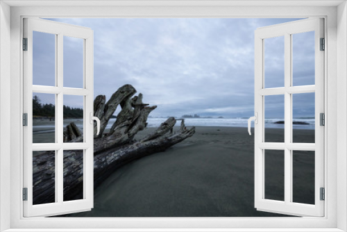 Fototapeta Naklejka Na Ścianę Okno 3D - Beautiful moody view on the sandy beach on the Pacific West Coast during a cloudy early morning. Taken in Tofino, Vancouver Island, British Columbia, Canada.
