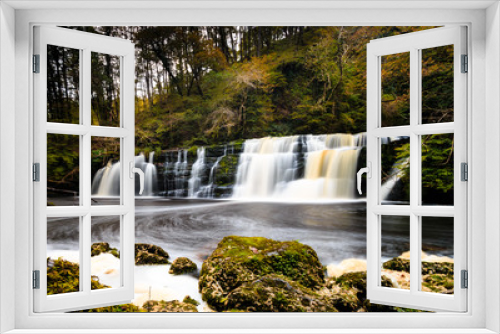 Fototapeta Naklejka Na Ścianę Okno 3D - Long exposure of a waterfall (Sgwd Y Pannwr) in a tree covered forest in the autumn