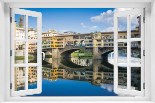 The Ponte Vecchio bridge reflected in the River Arno in Florence 