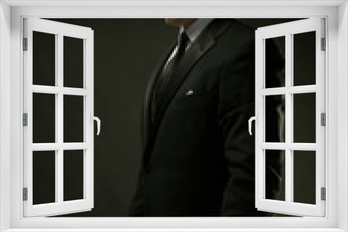 Fototapeta Naklejka Na Ścianę Okno 3D - The attractive man in black suit on dark background