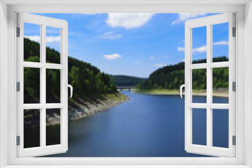 Fototapeta Naklejka Na Ścianę Okno 3D - Landscape with a lake surrounded by green fresh fir trees on a beautiful sunny summer day in the harz national park. 