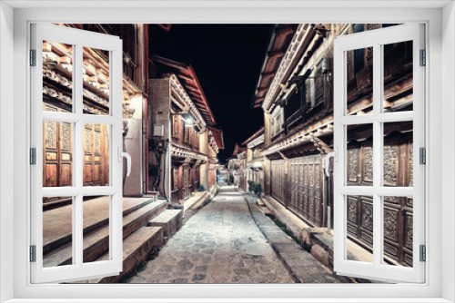 Fototapeta Naklejka Na Ścianę Okno 3D - Vintage toned picture of illuminated empty street of Shangri La Old Town (Dukezong) at night, China.