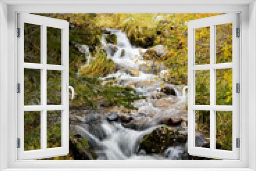 Fototapeta Naklejka Na Ścianę Okno 3D - A waterfall and stream cascading through the autumn foliage