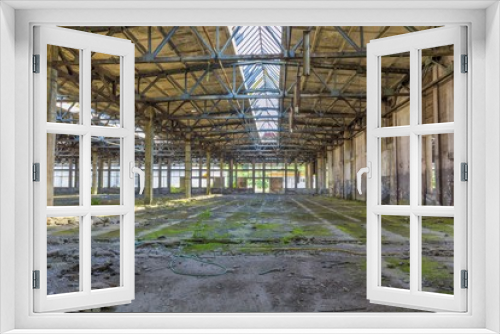 Fototapeta Naklejka Na Ścianę Okno 3D - Abandoned large factory industrial interior. Inside the ruins of an old factory  in Romania of a Communist Era. Step inside of abandoned old factory in eastern Europe.