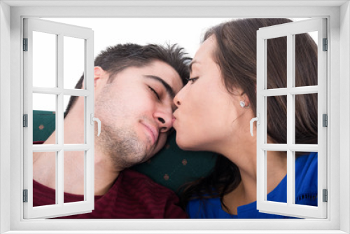 Student couple sitting on  couch kissing while studying