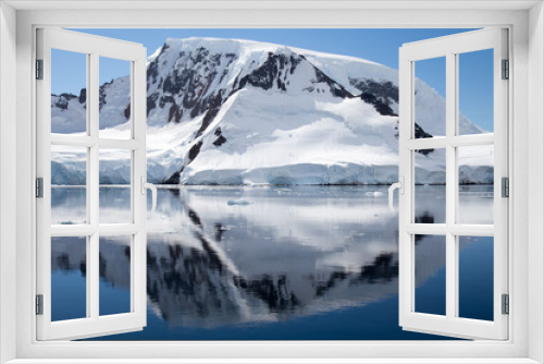 Fototapeta Naklejka Na Ścianę Okno 3D - A mountain in Antarctica reflects in the water.
