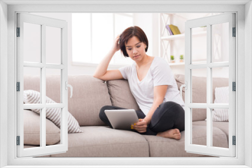 Pensive girl at home chatting online on tablet