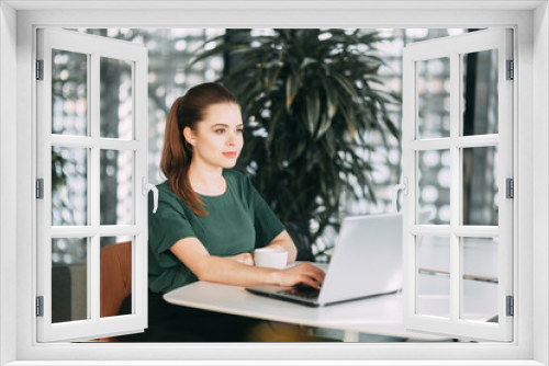 beautiful business lady at work with a laptop and phone sitting in the office