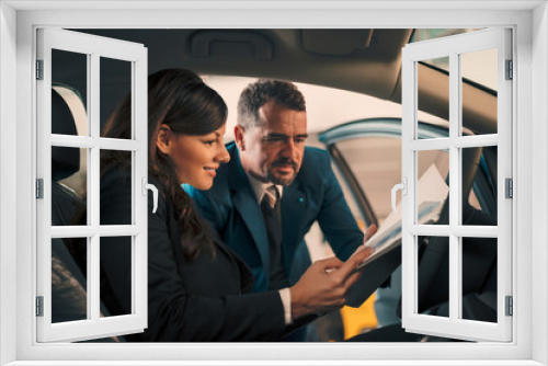 Happy woman inside car in auto salon with car dealer.