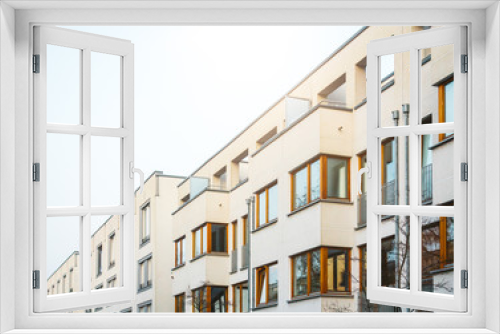 Fototapeta Naklejka Na Ścianę Okno 3D - white apartment buildings in a row with wooden windows