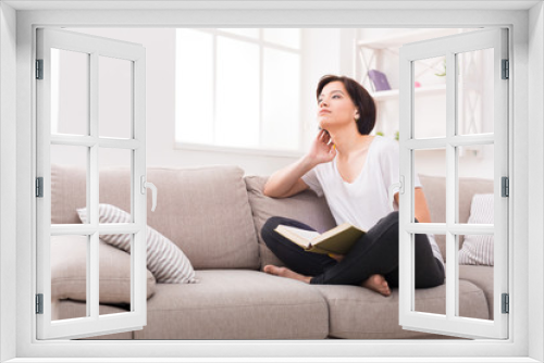 Young dreamy woman with a book