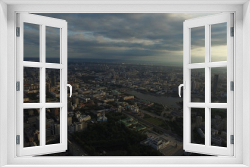 Fototapeta Naklejka Na Ścianę Okno 3D - Beautiful and amazing view over the town. You can see the streets, the houses, the big skyscraper, the sun's rays burst through the clouds