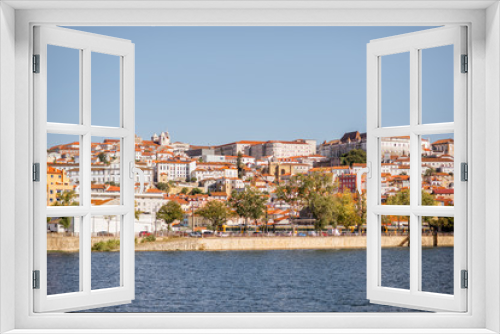 Cityscape view on the old town of Coimbra city with Mondego river during the sunny day in the central Portugal