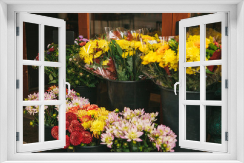 Fototapeta Naklejka Na Ścianę Okno 3D - Street shop of flowers - bouquets of peonies and chrysanthemums stand in black buckets.