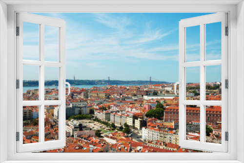Alfama downtown and the 25 April Bridge in Lisbon, Portugal.