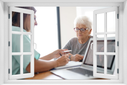 Nurse giving prescription to elderly woman