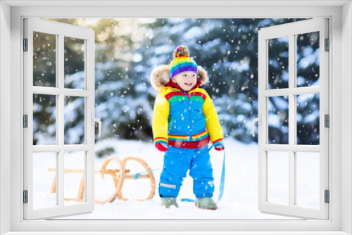 Boy on sleigh ride. Child sledding. Kid with sledge