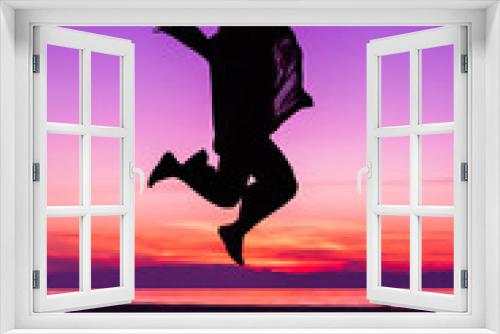 Fototapeta Naklejka Na Ścianę Okno 3D - Sihouette of Happy Woman Jumping with Joy , against beautiful after sunset purple color tones by the sea