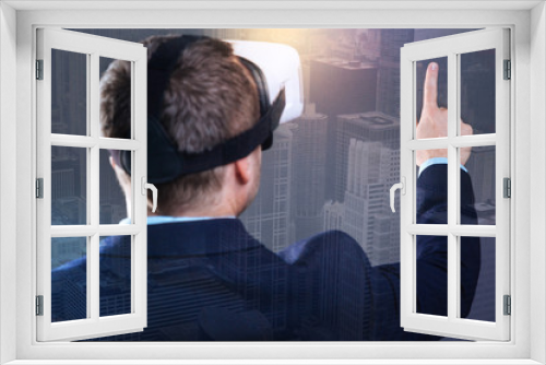 Innovative possibilities. Selective focus on a hand of a millennial businessman in a suit wearing virtual reality goggles pointing toward a skyscraper while enjoying a downtown view.