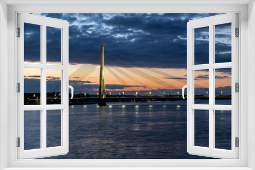 Fototapeta Naklejka Na Ścianę Okno 3D - View of the cable-stayed bridge and the embankment of the river Daugava in Riga at sunset.