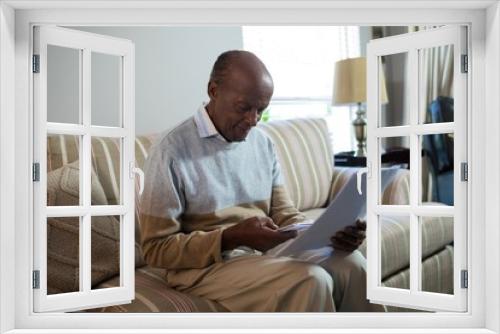 Senior man using phone while holding document