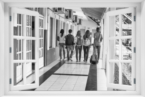 Back view of mixed race teenagers classroom walking in schoolyard