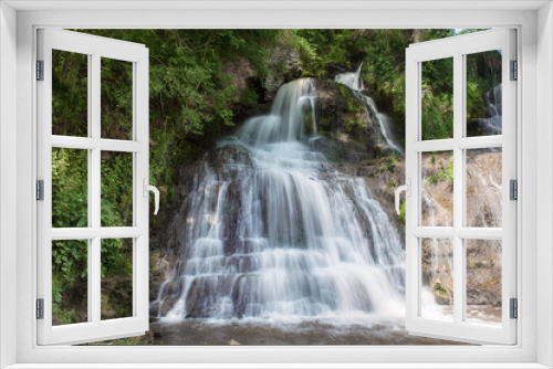 Fototapeta Naklejka Na Ścianę Okno 3D - Beautiful mountain rainforest waterfall with fast flowing water and rocks, long exposure. Natural seasonal travel outdoor background in hipster vintage style