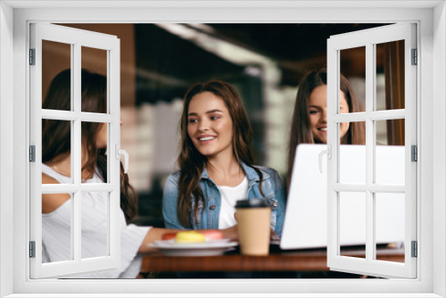 Girls In Cafe. Happy Friends Using Computer.