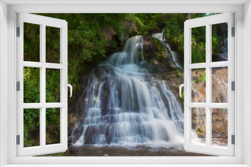 Fototapeta Naklejka Na Ścianę Okno 3D - Beautiful mountain rainforest waterfall with fast flowing water and rocks, long exposure. Natural seasonal travel outdoor background in hipster vintage style