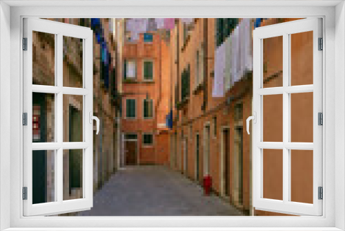 Fototapeta Naklejka Na Ścianę Okno 3D - Venice, Italy - August 14, 2017: windows of a multistory residential building with clothesline ropes.