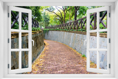Fototapeta Naklejka Na Ścianę Okno 3D - redbrick pathway or footpath with big stone wall in sunny day. underground crossing at fort canning public park,singapore. travel concept.