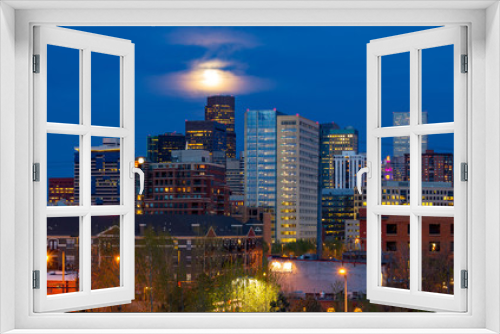 Fototapeta Naklejka Na Ścianę Okno 3D - Colorful lights of the Denver Colorado downtown skyline at night with the full moon glowing in the evening sky in the background