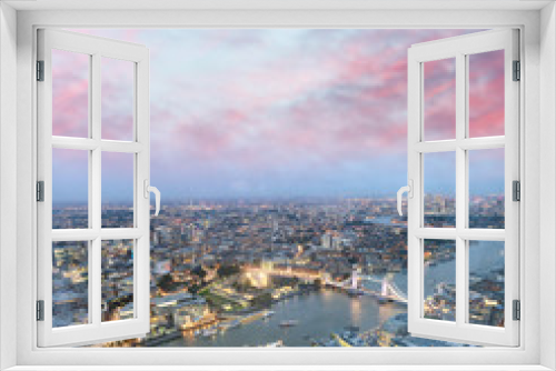 Tower Bridge and city skyline along river Thames at night, aerial view - London - UK