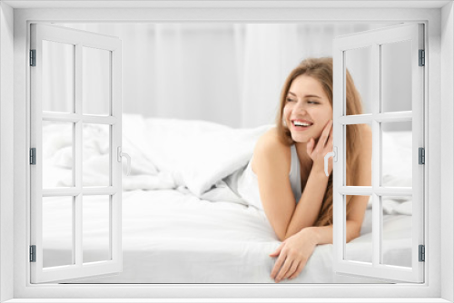 Portrait of beautiful smiling woman in bed at home