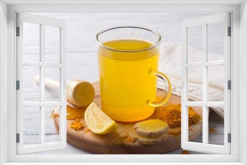 Fototapeta Naklejka Na Ścianę Okno 3D - Energy tonic drink with turmeric, ginger, lemon and honey on a wooden board, selective focus