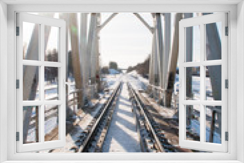 Fototapeta Naklejka Na Ścianę Okno 3D - Winter landscape with railroad bridge over frozen river, snow-covered trees