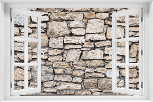 Fototapeta Naklejka Na Ścianę Okno 3D - Close-up textured background is an irregular natural stone wall made of different stones without a cement-type bonding mixture. Medieval background