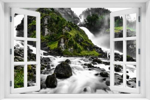 Fototapeta Naklejka Na Ścianę Okno 3D - Beautiful scenic wild waterfall flowing down from a mountain into the valley around rocks and forest in Norway
