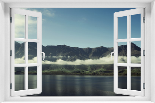 Fototapeta Naklejka Na Ścianę Okno 3D - Paisaje de montañas con picos nevados y nubes. Las montañas se reflejan en un lago. Escena diurna, cielo azul y despejado. Nueva Zelanda.