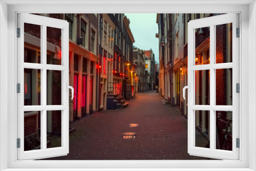 Fototapeta Naklejka Na Ścianę Okno 3D - Red light district in Amsterdam, the Netherlands, night view. Windows and doors where prostitutes work