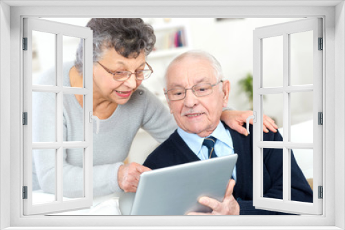 old couple looking camera with tablet pc in their hands