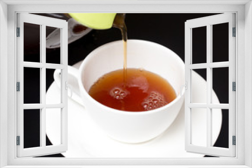 Fototapeta Naklejka Na Ścianę Okno 3D - Tea in a cup on a black background