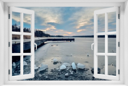 Fototapeta Naklejka Na Ścianę Okno 3D - Evening winter landscape. Wooden pier over a beautiful frozen lake.