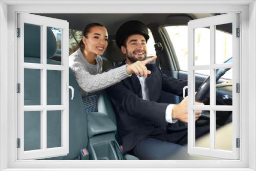 Young female passenger showing taxi driver the way