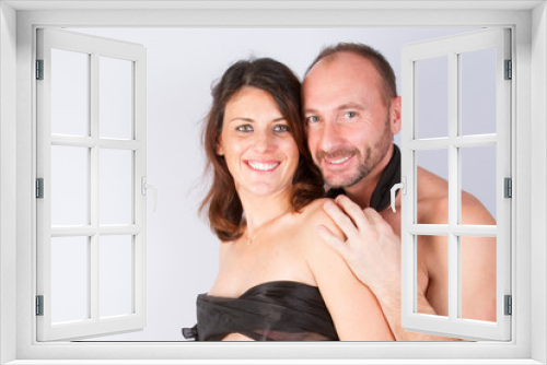 Beautiful and happy young couple in love or family posing on a gray background isolated