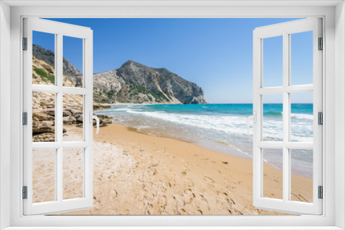 Fototapeta Naklejka Na Ścianę Okno 3D - Beautiful sunny coast view to the greek mediterranean blue sea with crystal clear water and pure sandy beach empty place with some mountains rocks surrounded, Kos, Dodecanese Islands, Greece