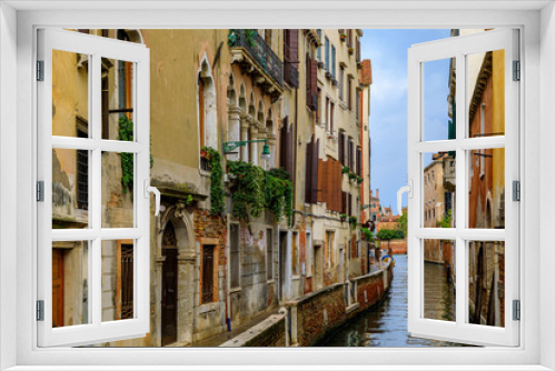 Fototapeta Naklejka Na Ścianę Okno 3D - Weathered building facade on a picturesque canal in Venice Italy