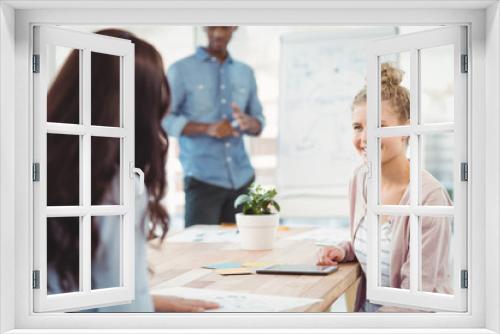 Smiling woman discussing with coworker 