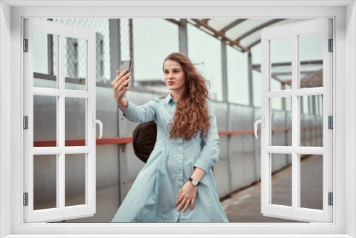 Girl on the bridge. Attractive lady stands by the sea